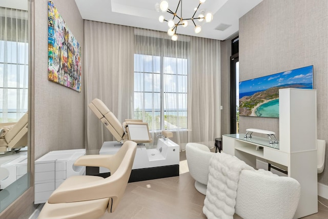 living area featuring a chandelier and a raised ceiling