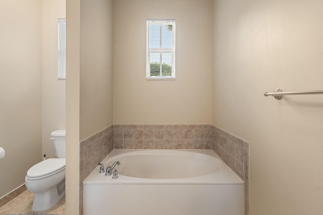 bathroom featuring a garden tub, toilet, and tile patterned floors