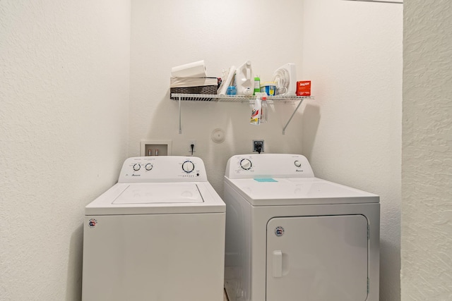 laundry area with a textured wall, laundry area, and washer and dryer