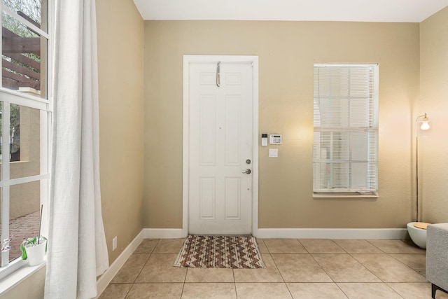 entrance foyer with light tile patterned floors and baseboards