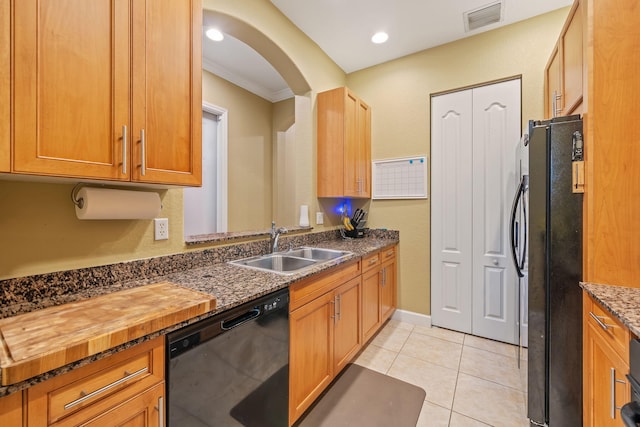 kitchen with arched walkways, light tile patterned floors, visible vents, a sink, and black appliances