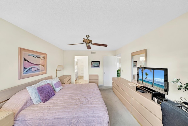 carpeted bedroom featuring ceiling fan, ensuite bath, and a textured ceiling