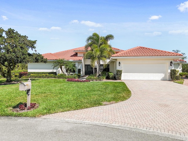 mediterranean / spanish house with a garage and a front yard