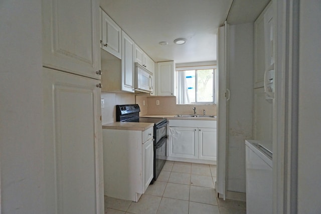 kitchen featuring light tile patterned flooring, sink, range with two ovens, white cabinetry, and decorative backsplash