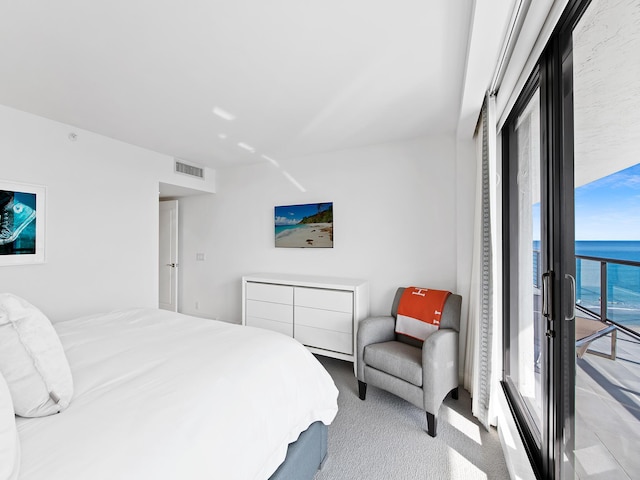 bedroom with a water view and light colored carpet