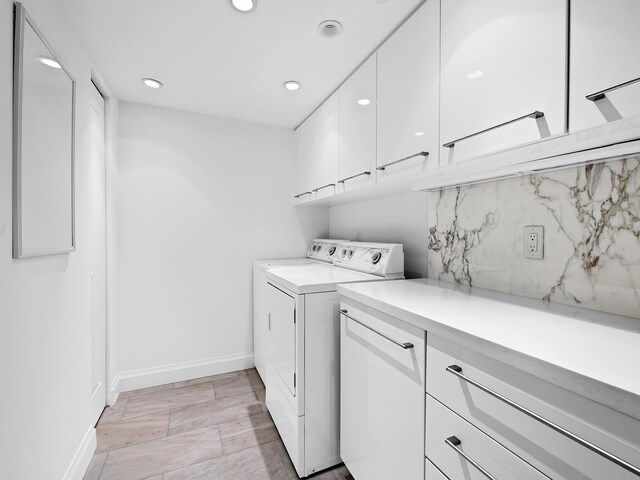 laundry area with washing machine and dryer and cabinets