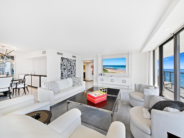 living room featuring a water view and a notable chandelier