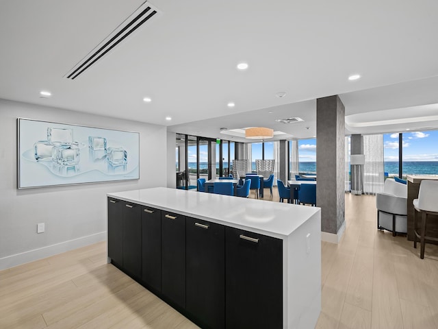 kitchen featuring a water view, light wood-type flooring, and a large island