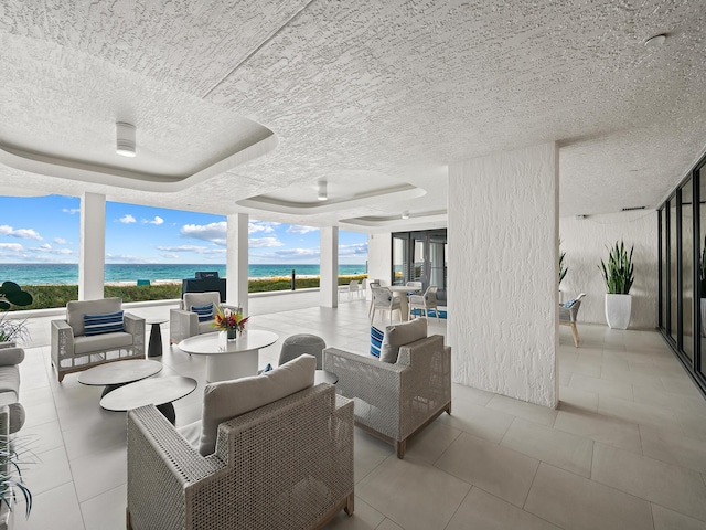 interior space with outdoor lounge area and a water view