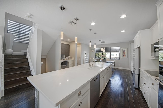 kitchen featuring white cabinets, dark wood-type flooring, stainless steel appliances, and a sink