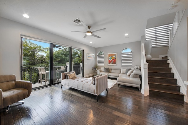 living area featuring baseboards, visible vents, ceiling fan, stairway, and dark wood-style flooring