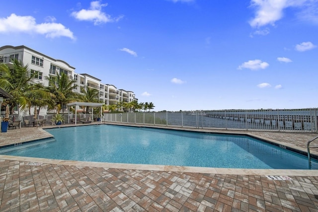 community pool with a patio area and fence