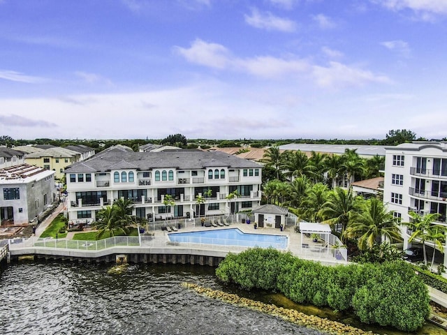 exterior space featuring a patio, a water view, a residential view, and a community pool