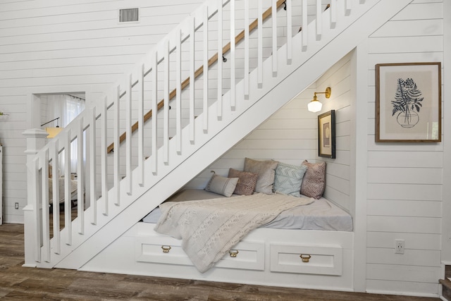 stairway with wood-type flooring and wood walls