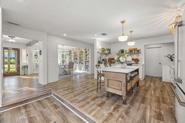 kitchen featuring a kitchen island, dark wood-type flooring, a chandelier, and decorative light fixtures