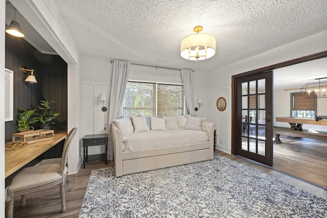 living room featuring french doors, wood-type flooring, and a textured ceiling