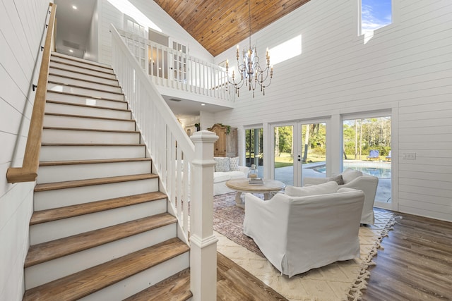 living room with wood-type flooring, high vaulted ceiling, french doors, and a healthy amount of sunlight