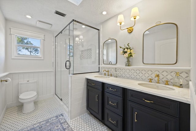 bathroom featuring tile patterned flooring, vanity, toilet, and walk in shower