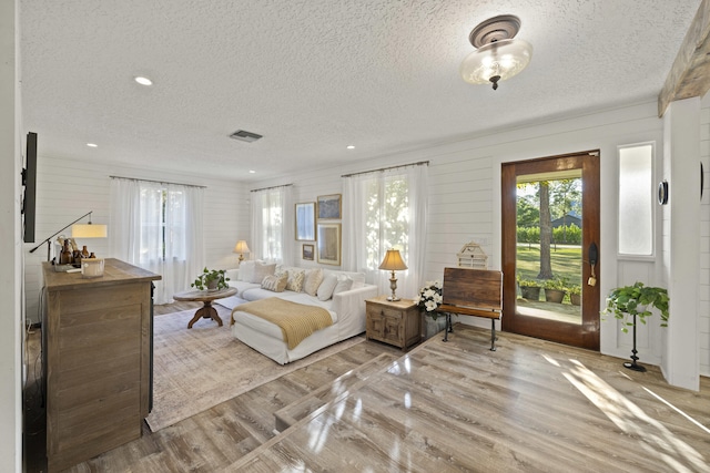 living room featuring light hardwood / wood-style floors and a textured ceiling