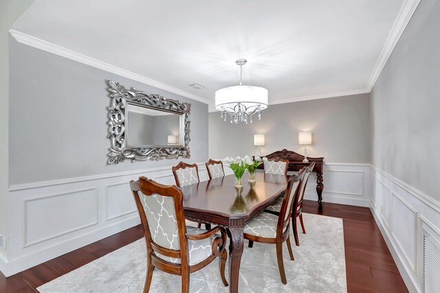 dining room featuring ornamental molding, a notable chandelier, and dark hardwood / wood-style flooring