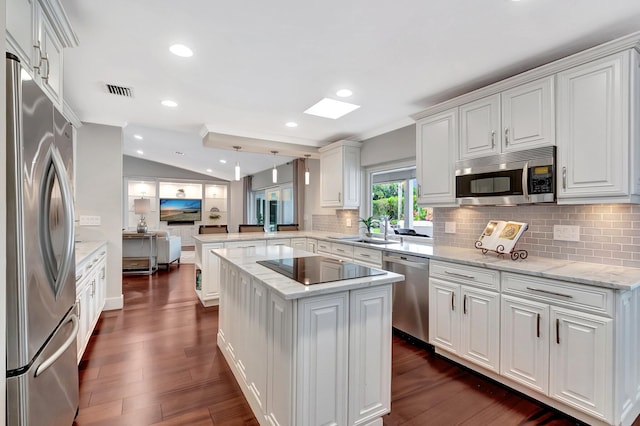 kitchen featuring white cabinetry, hanging light fixtures, a center island, kitchen peninsula, and stainless steel appliances