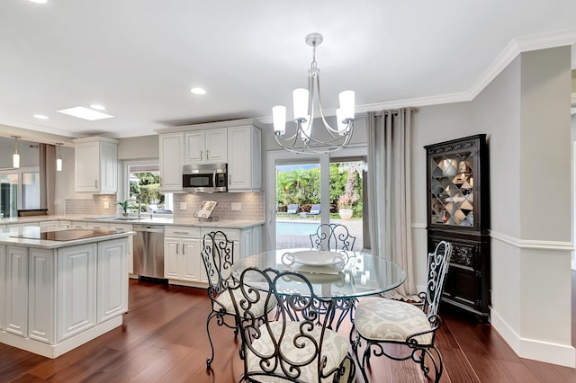 dining room with crown molding, sink, a notable chandelier, and dark hardwood / wood-style flooring