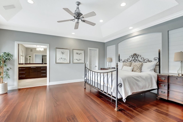 bedroom featuring connected bathroom, ornamental molding, dark hardwood / wood-style flooring, a raised ceiling, and ceiling fan with notable chandelier