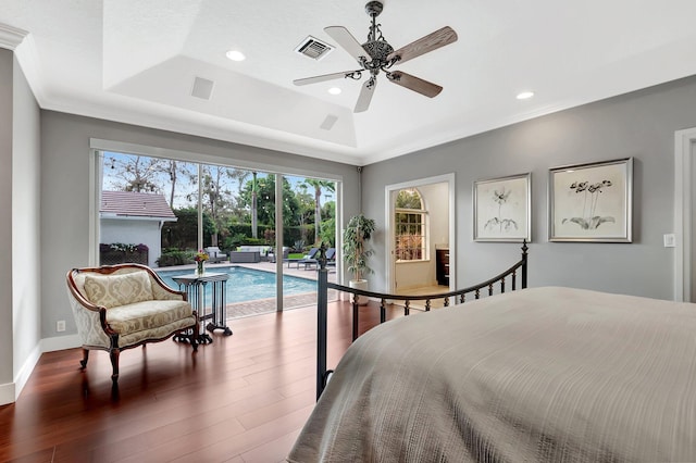 bedroom featuring ceiling fan, access to exterior, dark hardwood / wood-style floors, ornamental molding, and a raised ceiling