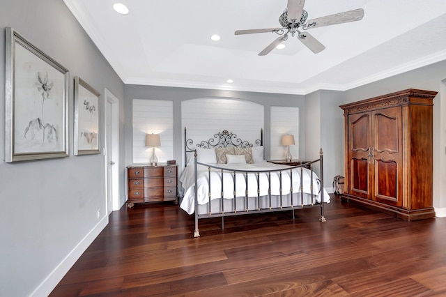 bedroom with crown molding, ceiling fan, dark hardwood / wood-style floors, and a raised ceiling