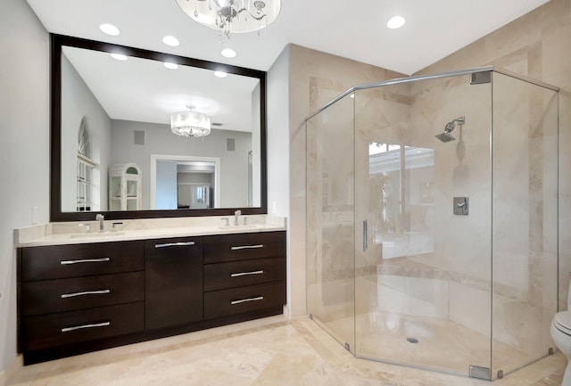 bathroom with vanity, toilet, a shower with door, and a notable chandelier