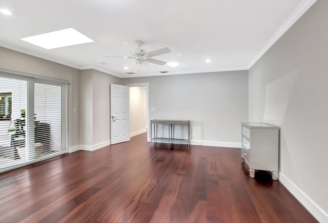 unfurnished living room featuring crown molding, ceiling fan, dark hardwood / wood-style floors, and a skylight