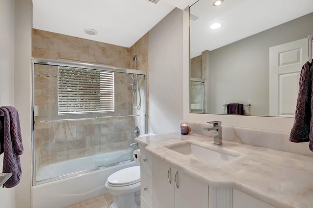 full bathroom with vanity, bath / shower combo with glass door, and toilet