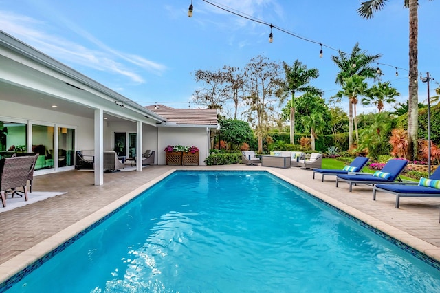 view of swimming pool with outdoor lounge area and a patio