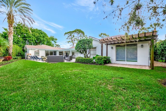 rear view of property featuring outdoor lounge area, a patio area, and a lawn