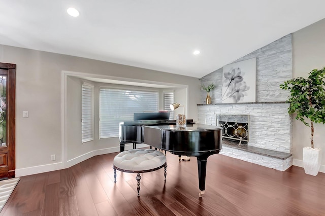 misc room with lofted ceiling, dark wood-type flooring, and a fireplace