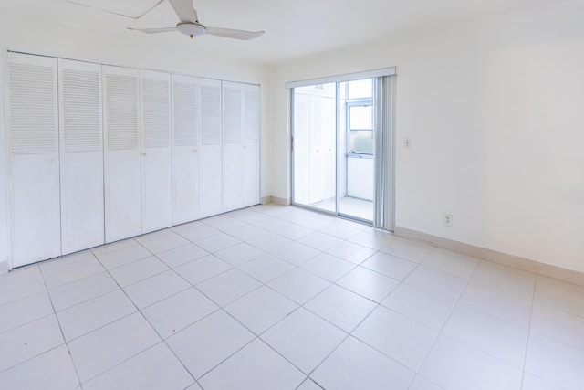 unfurnished bedroom with light tile patterned floors, a closet, and ceiling fan