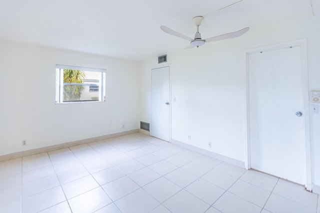 tiled empty room with ceiling fan