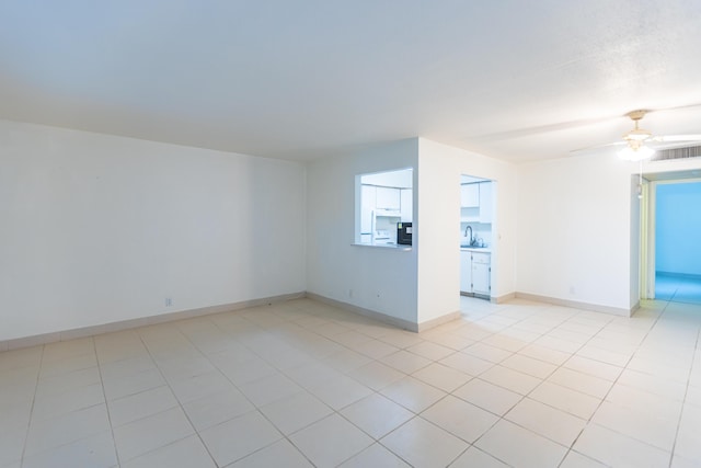 spare room featuring sink, light tile patterned floors, and ceiling fan