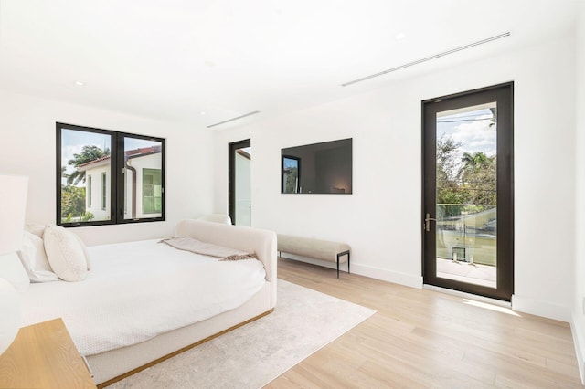 bedroom with access to exterior and light wood-type flooring