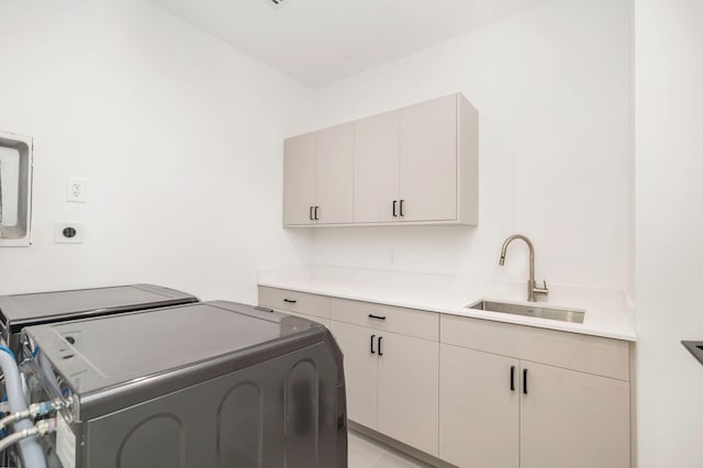 laundry room with sink, washer and clothes dryer, and cabinets