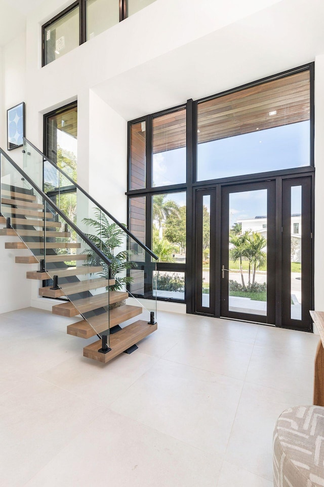 foyer with a wall of windows, a towering ceiling, and a wealth of natural light