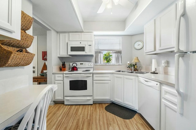 kitchen with white appliances, light wood-type flooring, sink, and white cabinets