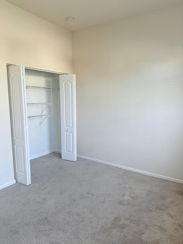 unfurnished bedroom with carpet floors and a closet
