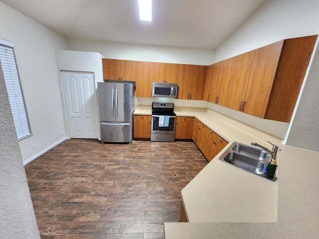 kitchen with dark wood-type flooring, lofted ceiling, stainless steel appliances, and sink