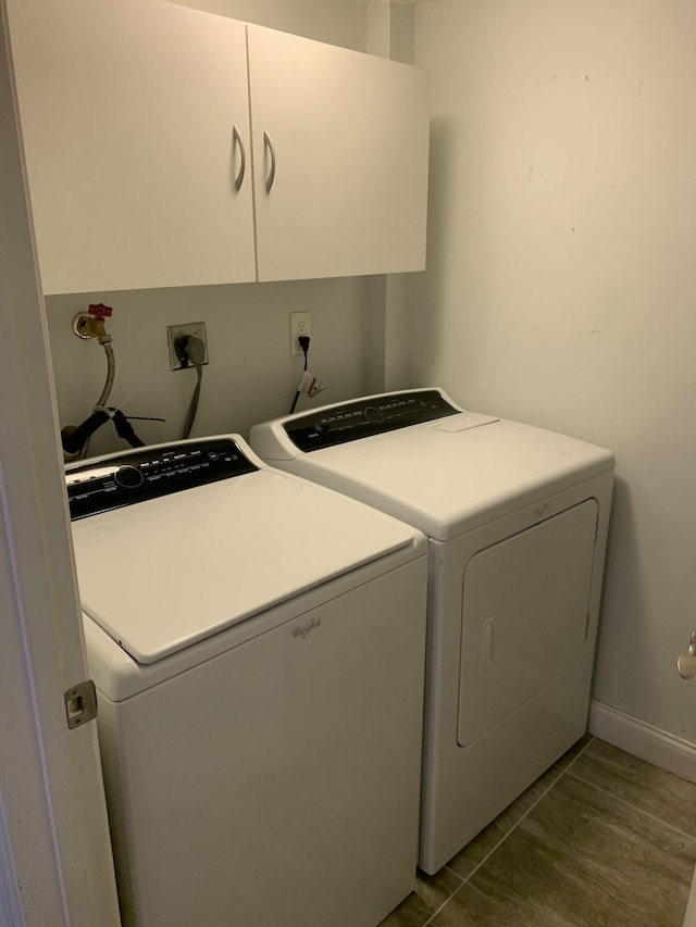 washroom featuring cabinets, washing machine and dryer, and hardwood / wood-style floors