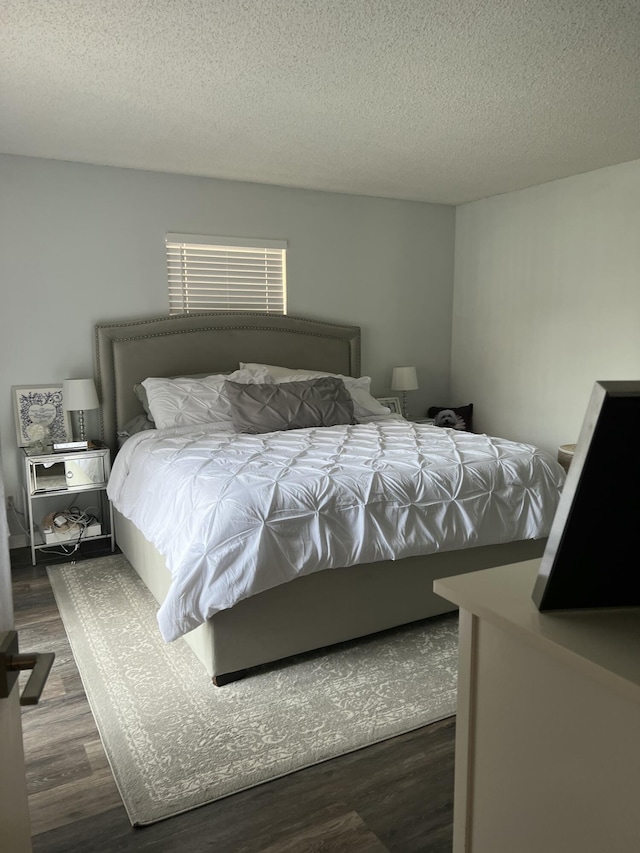 bedroom featuring dark hardwood / wood-style floors and a textured ceiling