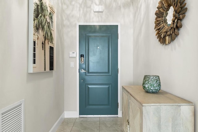 doorway to outside with light tile patterned floors, visible vents, and baseboards