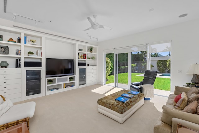 carpeted living room featuring ceiling fan and track lighting