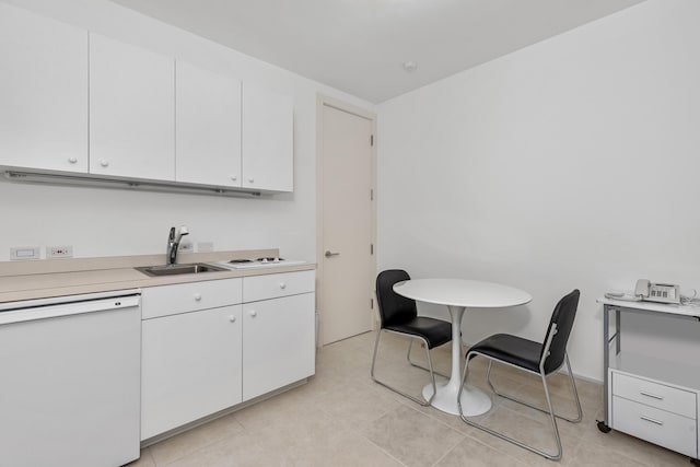 kitchen with light tile patterned floors, white dishwasher, sink, and white cabinets