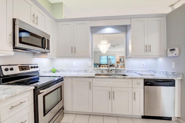 kitchen featuring white cabinetry, sink, stainless steel appliances, and light stone countertops